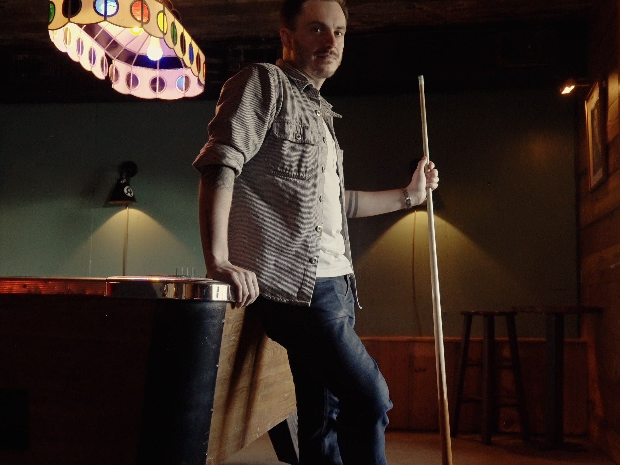 Peter Stanislaus, a man holding a pool cue wearing The Hynes Whiskey