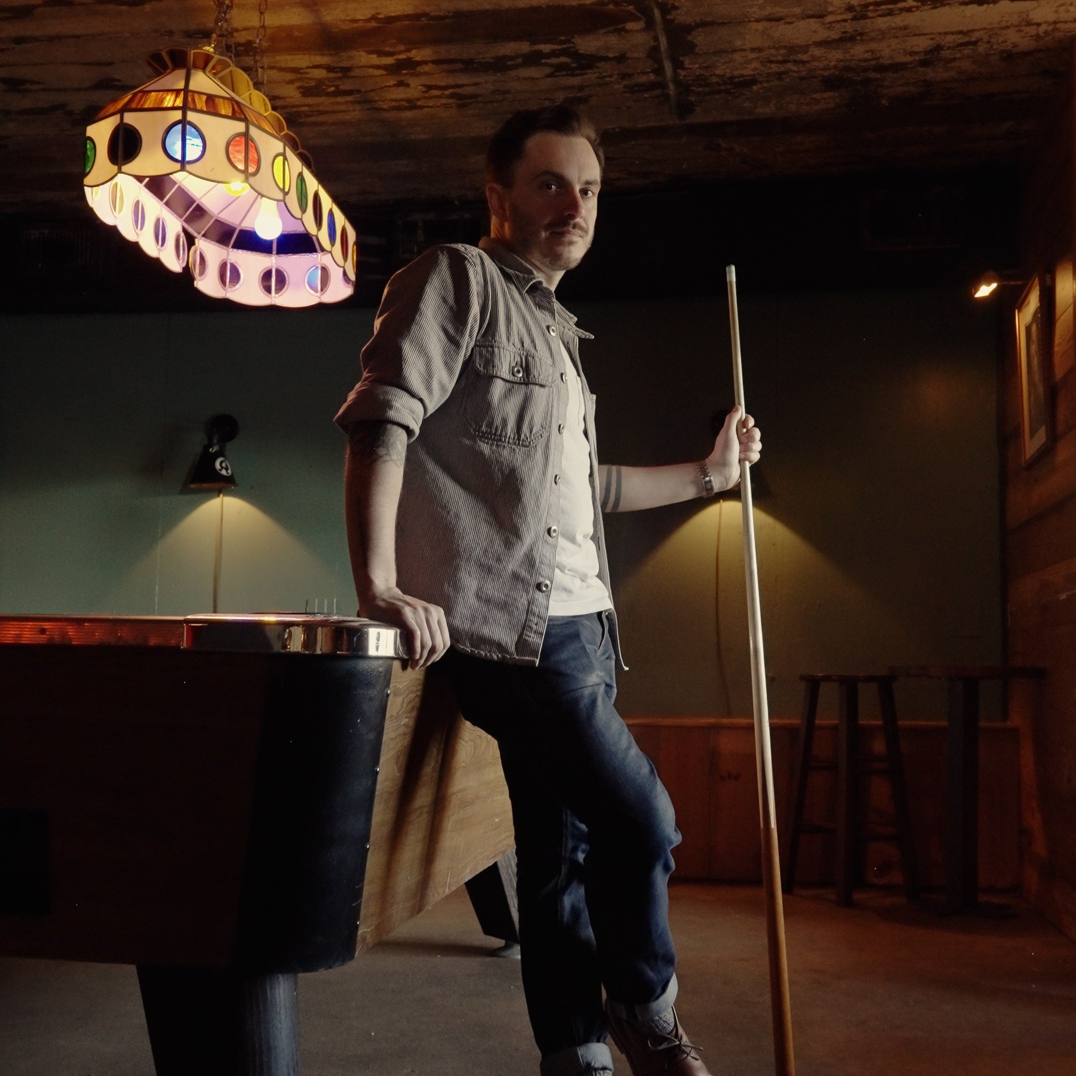 Peter Stanislaus, a man holding a pool cue wearing The Hynes Whiskey